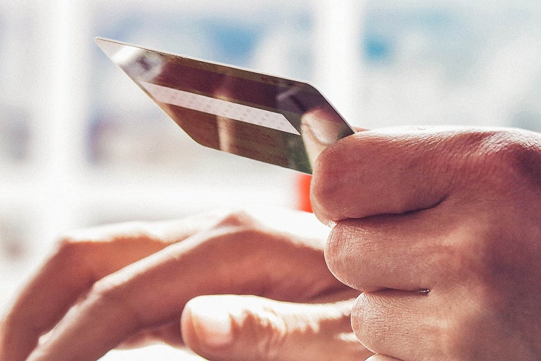 A hand holding a credit card.